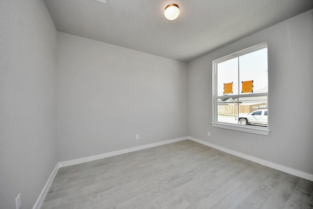 unfurnished room featuring baseboards and wood finished floors