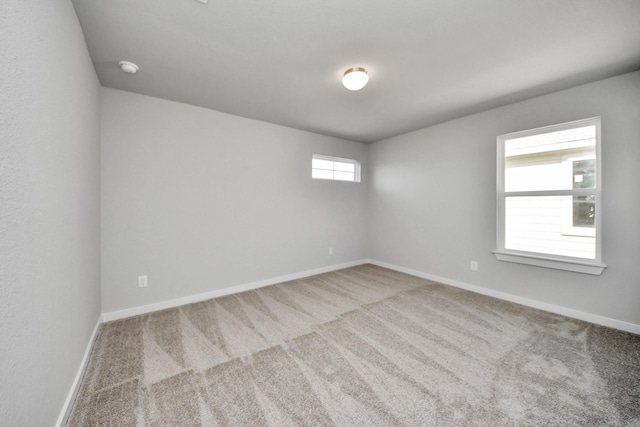 spare room featuring baseboards and carpet flooring
