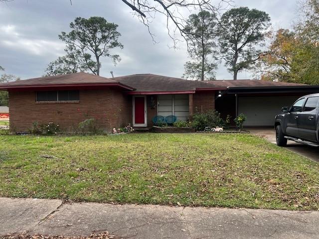 ranch-style house featuring a front lawn and a carport