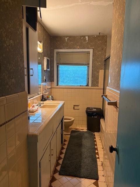 bathroom featuring tile walls, vanity, tile patterned floors, and toilet