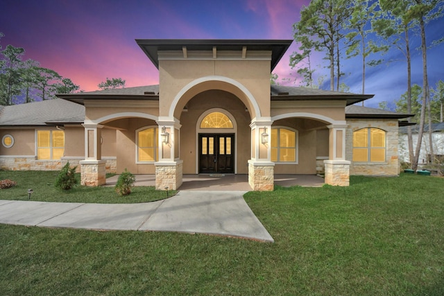 view of front of home with a lawn and french doors