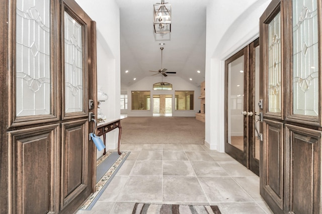 carpeted foyer with french doors, ceiling fan, and vaulted ceiling