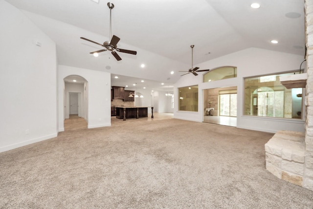 unfurnished living room with ceiling fan, vaulted ceiling, and light carpet