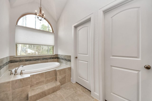 bathroom featuring tiled bath, vaulted ceiling, tile patterned floors, and a chandelier