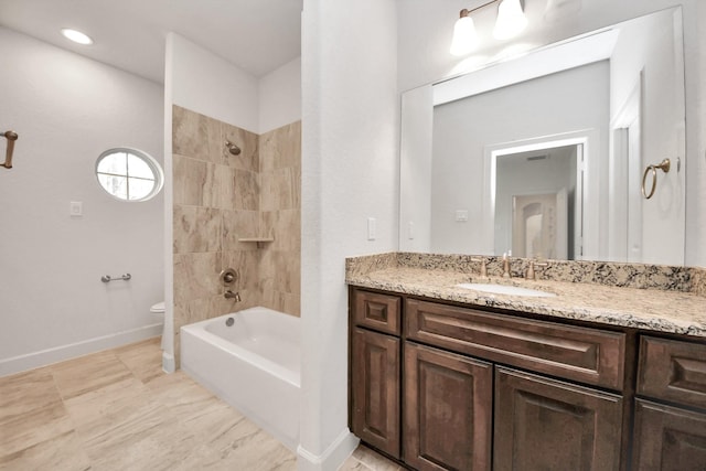 full bathroom featuring toilet, vanity, and tiled shower / bath