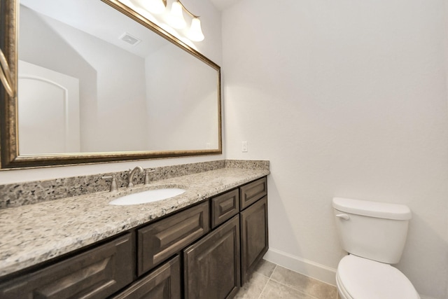 bathroom with toilet, tile patterned flooring, and vanity