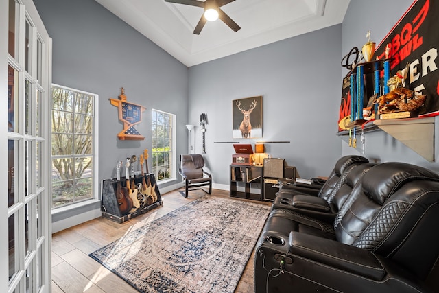 living room featuring a tray ceiling, ceiling fan, french doors, and light hardwood / wood-style floors