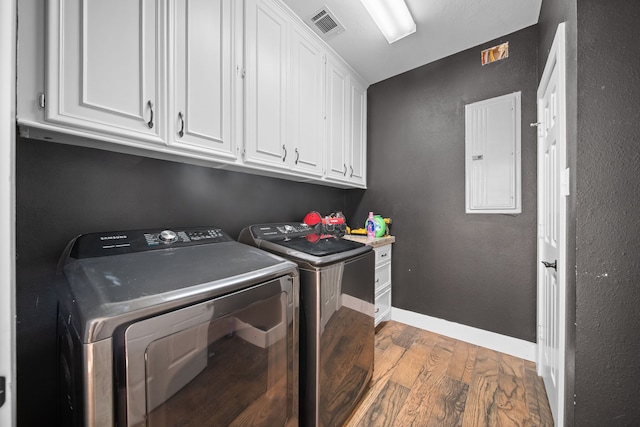 washroom featuring cabinets, independent washer and dryer, electric panel, and hardwood / wood-style flooring