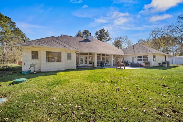 back of property with a lawn, a patio area, french doors, and central AC