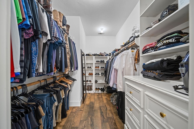 walk in closet with dark wood-type flooring