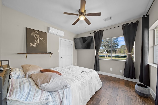 bedroom featuring dark hardwood / wood-style flooring, a wall unit AC, and ceiling fan