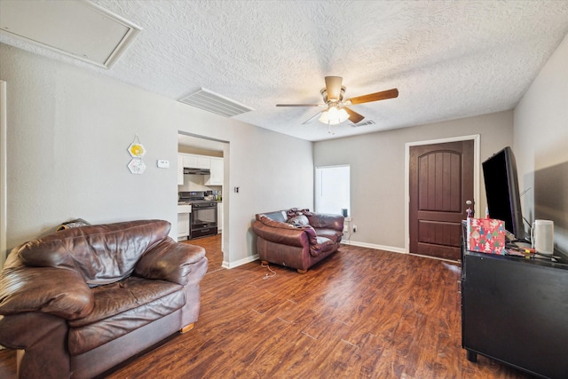 living room with ceiling fan, dark hardwood / wood-style flooring, and a textured ceiling