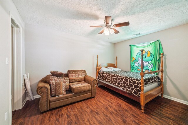 bedroom with a textured ceiling, ceiling fan, and dark hardwood / wood-style floors