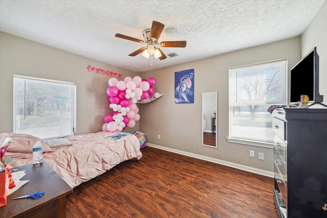 bedroom with a textured ceiling, dark hardwood / wood-style flooring, and ceiling fan