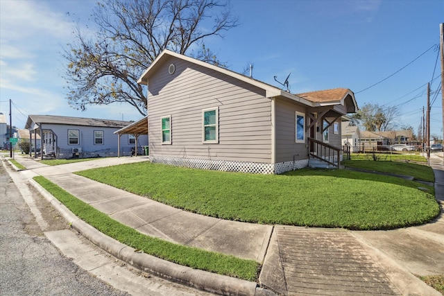 view of side of property featuring a lawn and a carport