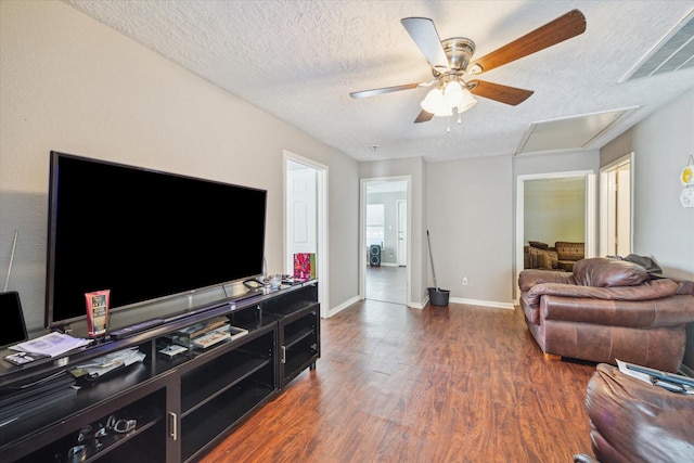 living room featuring ceiling fan, dark hardwood / wood-style flooring, and a textured ceiling