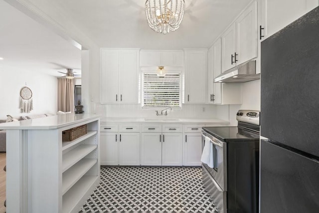 kitchen featuring kitchen peninsula, decorative light fixtures, stainless steel range with electric stovetop, black refrigerator, and white cabinets