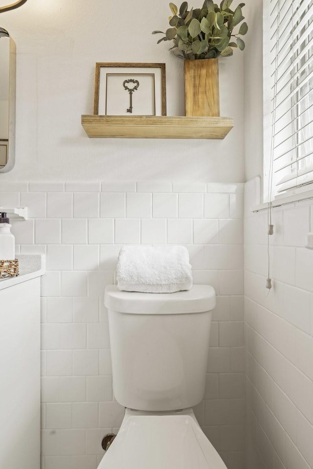 bathroom with tile walls and toilet