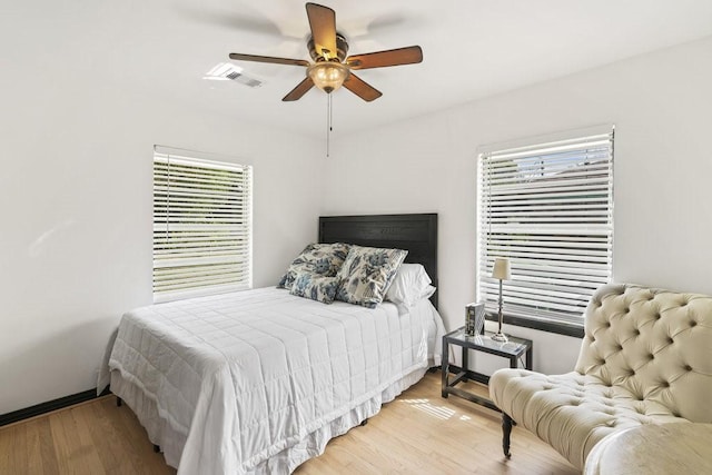 bedroom with ceiling fan, light hardwood / wood-style flooring, and multiple windows