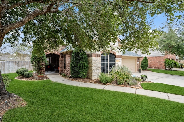 view of property hidden behind natural elements featuring a garage and a front yard