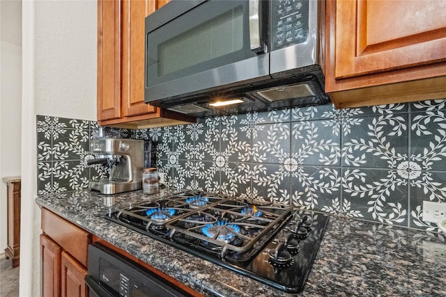 kitchen with black gas cooktop, decorative backsplash, and dark stone countertops