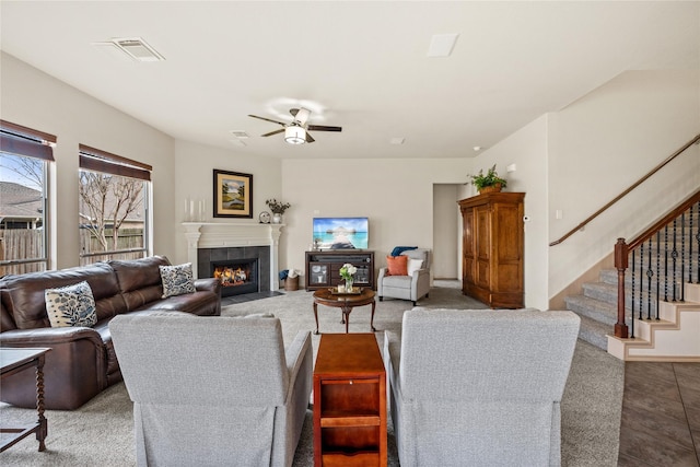 living room with ceiling fan and a tile fireplace