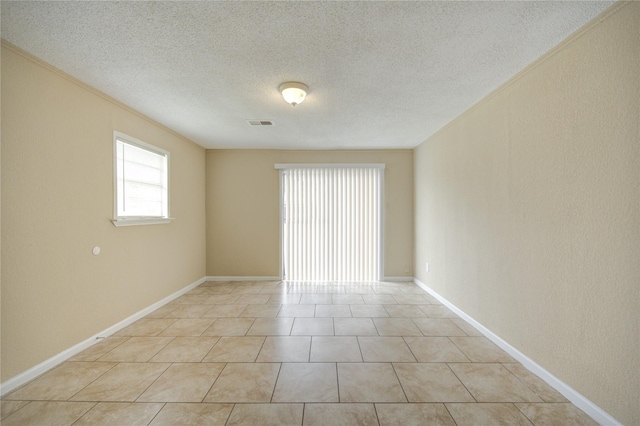 tiled spare room featuring a textured ceiling