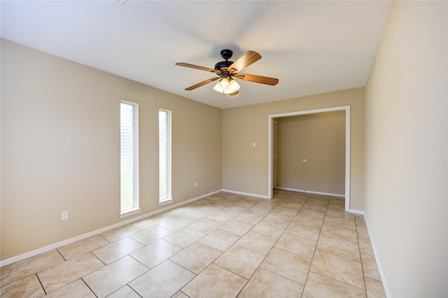 tiled empty room featuring ceiling fan