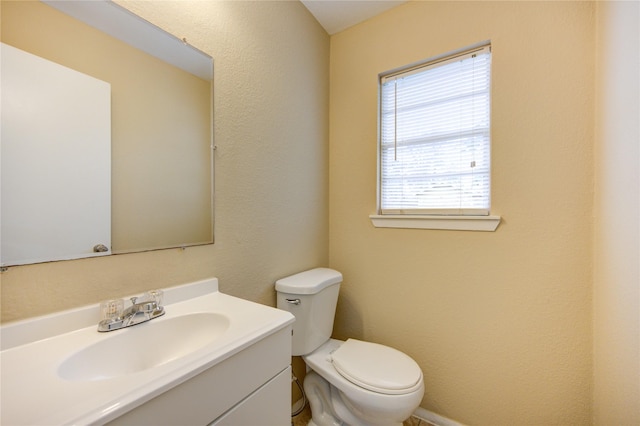 bathroom featuring vanity, a healthy amount of sunlight, and toilet