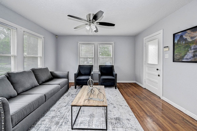 living room featuring a textured ceiling, dark hardwood / wood-style flooring, and ceiling fan