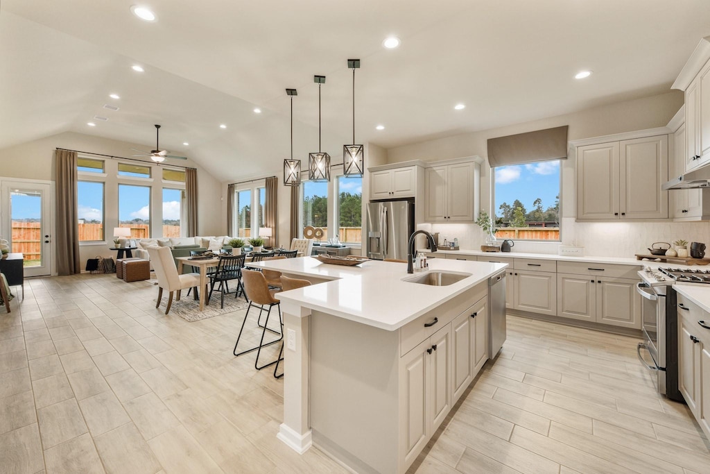 kitchen with sink, ceiling fan, an island with sink, appliances with stainless steel finishes, and white cabinetry