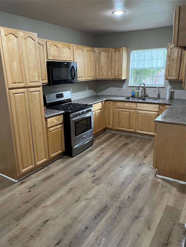 kitchen featuring sink, light wood-type flooring, light brown cabinetry, backsplash, and gas range