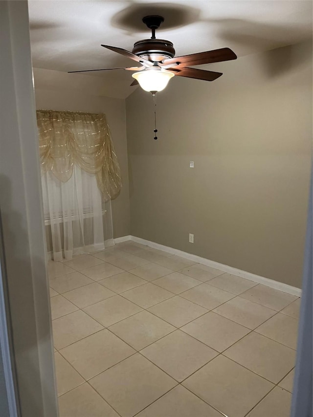 tiled spare room with ceiling fan