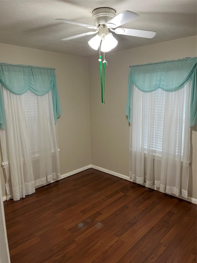 spare room featuring ceiling fan, dark wood-type flooring, and a textured ceiling