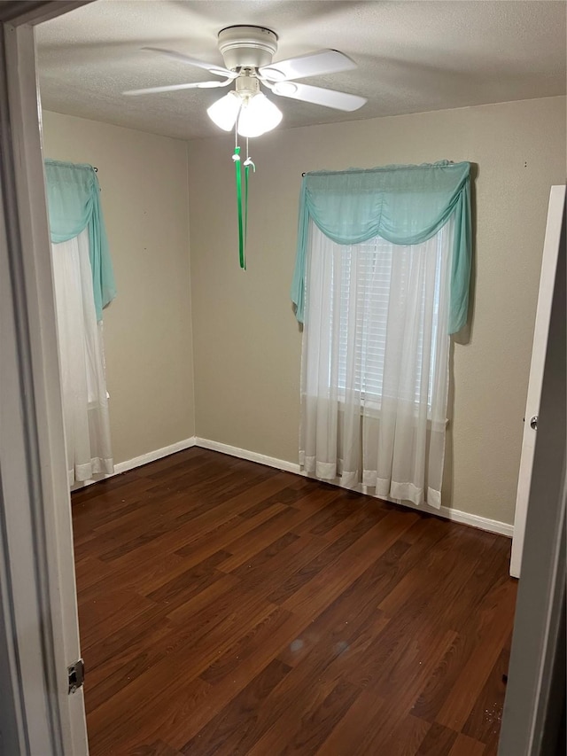 unfurnished room featuring ceiling fan and dark wood-type flooring