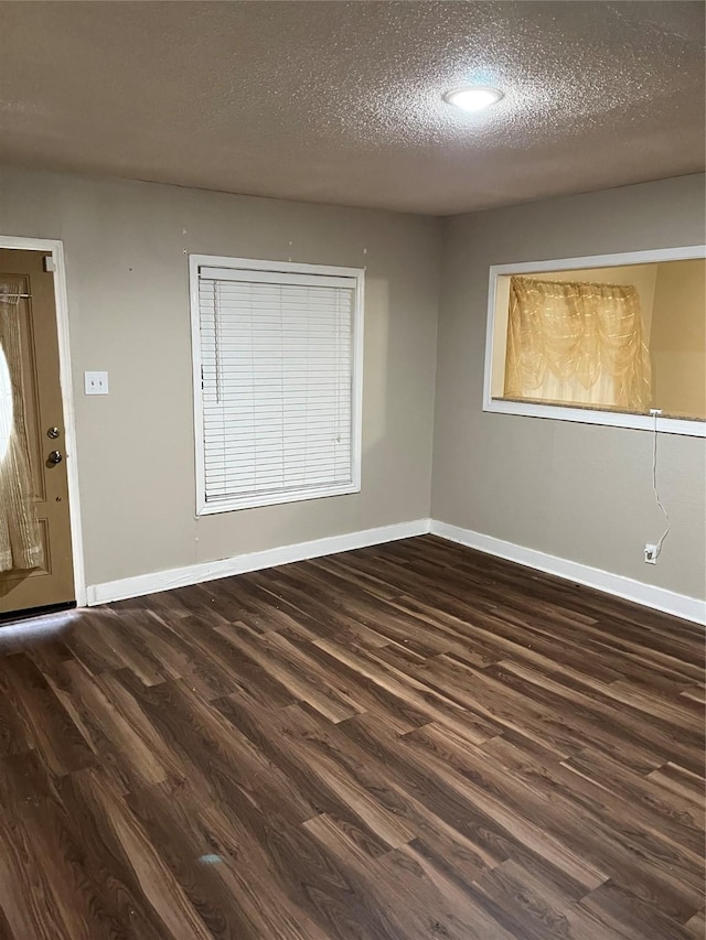 interior space featuring a textured ceiling and dark hardwood / wood-style flooring