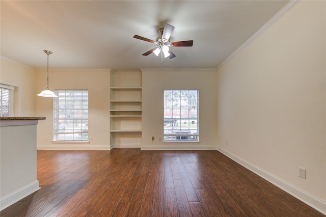 unfurnished living room featuring a wealth of natural light, dark wood-type flooring, and ornamental molding