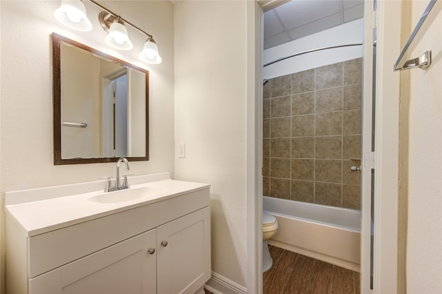 full bathroom featuring hardwood / wood-style flooring, vanity, toilet, and tiled shower / bath