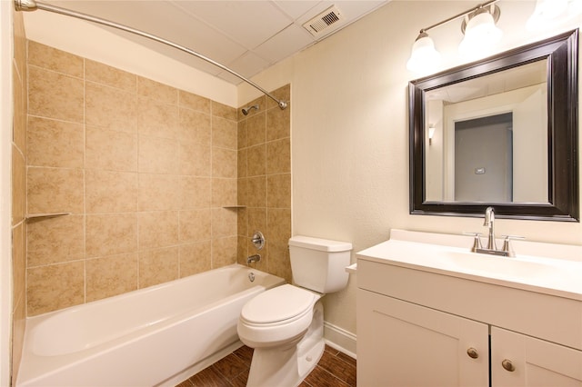 full bathroom with hardwood / wood-style flooring, vanity, toilet, and tiled shower / bath