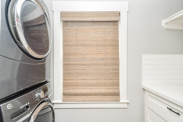 washroom featuring stacked washer and clothes dryer