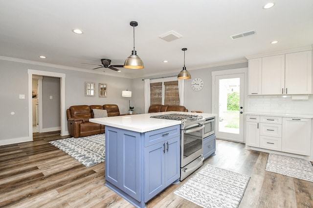 kitchen featuring a center island, gas stove, white cabinetry, and hanging light fixtures