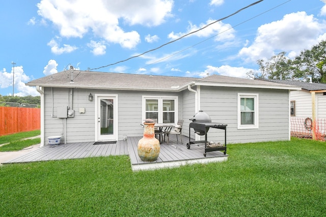 rear view of property with a yard and a deck