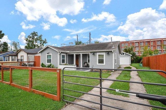 view of front of property featuring an outdoor structure, a front yard, and a garage