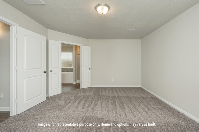 carpeted empty room with a textured ceiling