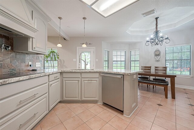 kitchen featuring dishwasher, premium range hood, backsplash, a tray ceiling, and light tile patterned flooring