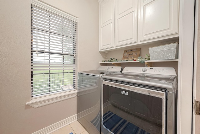 laundry room featuring cabinets, independent washer and dryer, and light tile patterned floors