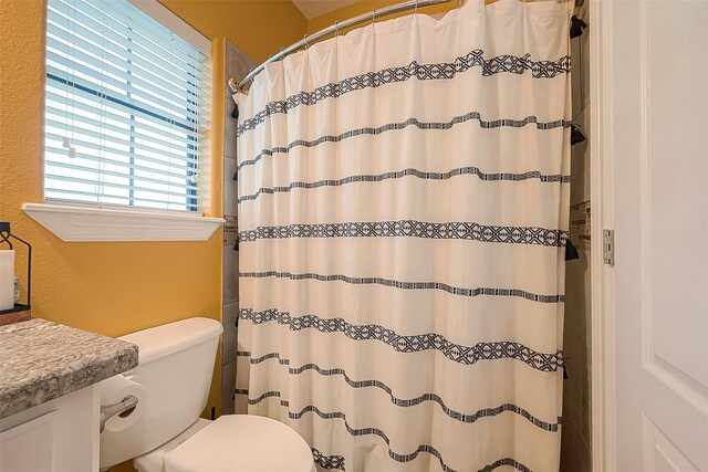 bathroom featuring a shower with curtain, vanity, and toilet