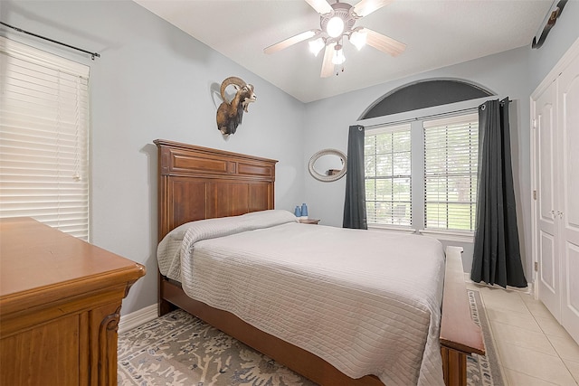 tiled bedroom featuring ceiling fan