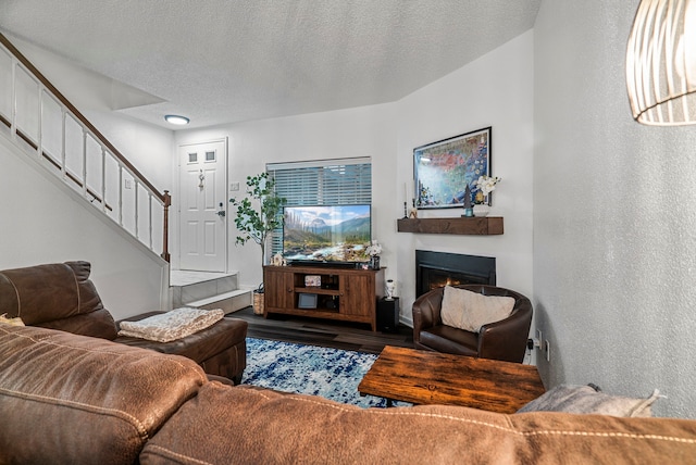 living room featuring wood-type flooring and a textured ceiling