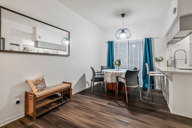 dining room featuring a textured ceiling, dark hardwood / wood-style flooring, and sink